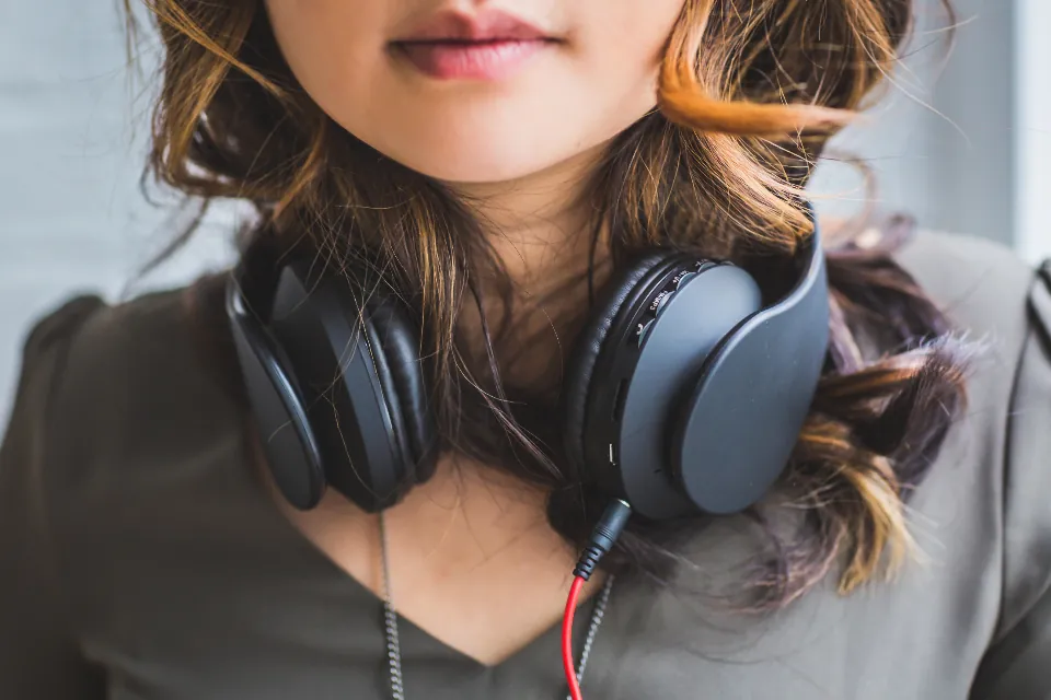 Jovem com fones de ouvido grandes apoiados no pescoço