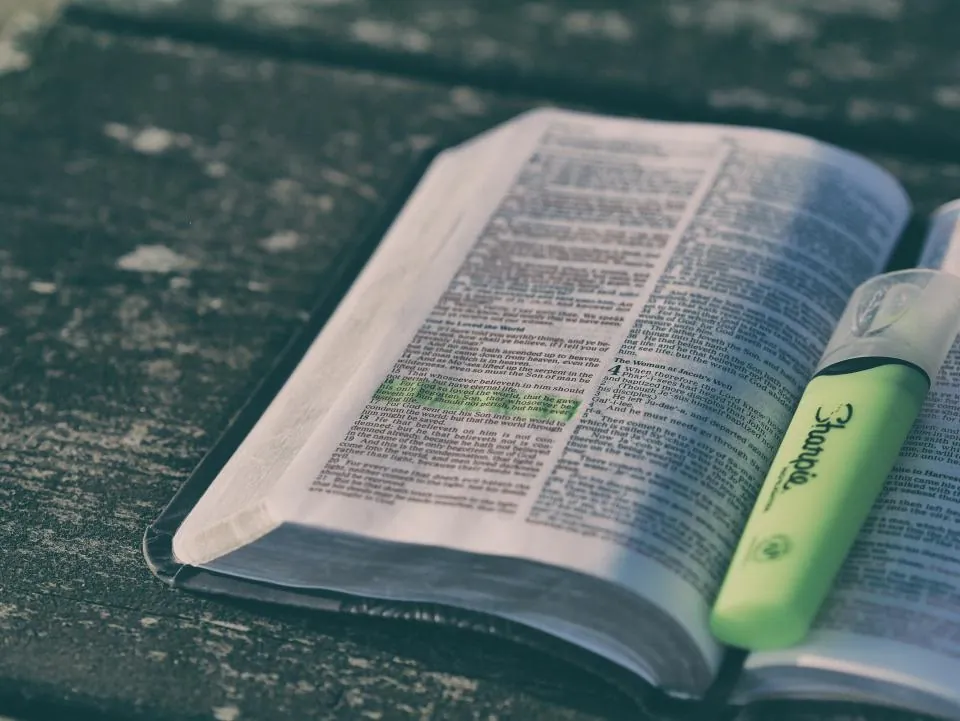 Bíblia aberta com um versículo destacado por um marca-texto verde